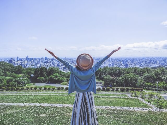 外で手を広げる女性